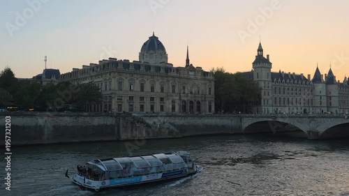 Seine River Cruise Boat Passing Historic Buildings at Sunset in Paris France
