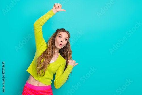 Schilderij op canvas Joyful young woman in vibrant outfit gesturing on teal background