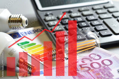 Closeup of energy save light bulb, calculator and electric plug over printed graph. Expensive energy bill and rise in electricity prices. Rising price chart.