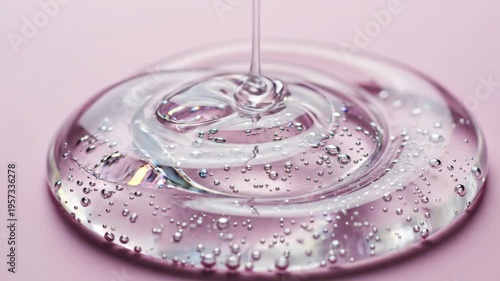 A cosmetic clear transparent gel serum sits on a pink background with generous copy space in a skincare product composition.