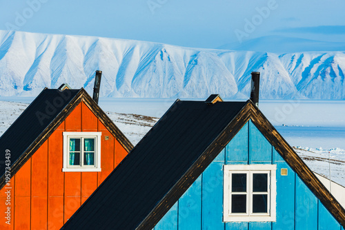 Fotografía Colorful buildings in Qaanaaq, Greenland with snowy mountains in the background