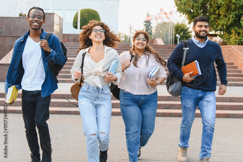 Diverse students walking on campus smiling happily