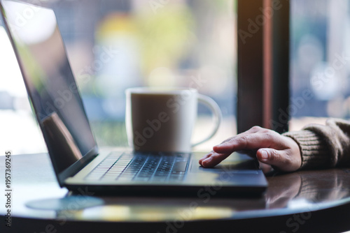 Closeup image of a hand working and touching on laptop computer touchpad