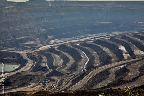 Panoramic view of a large open-pit coal mine revealing terraced benches and haul roads, illustrating best practices in mine planning, slope stability, and controlled traffic flow. 