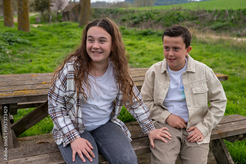 Young boy and girl enjoying nature on wooden bench