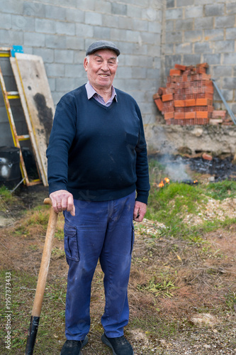 Elderly man smiling portrait holding shovel outdoor