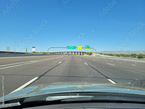 First-person view from a vehicle driving west toward Los Angeles on a multi-lane I-10 interstate freeway in a desert environment of Phoenix, Arizona