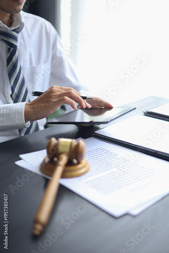 Lawyer working in office investigate the case by reading documents, using laptop and tablet.
