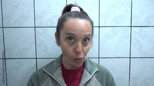 Kas, Turkey - 9 of February 2026: 4K Caucasian woman examining her face in the mirror with a displeased facial expression
