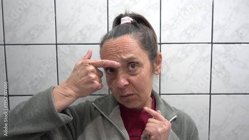Kas, Turkey - 9 of February 2026: 4K Woman looks upset examining her face in the mirror
