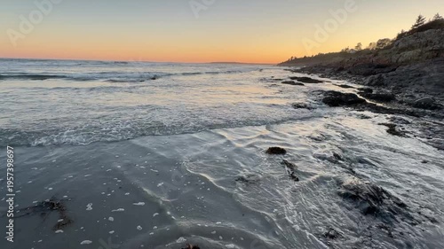 Rolling Ocean Tide at Rocky Shore with Tufts of Seaweed