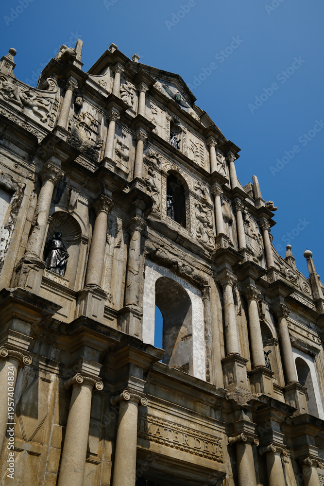 Fototapeta premium Iconic ruins of St Paul Cathedral historic stone facade with sculptures and carvings in Macau UNESCO heritage