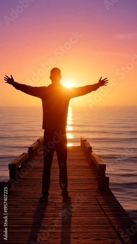 A person stands in silhouette at sunset, embracing the beauty of tranquility and freedom by the ocean.