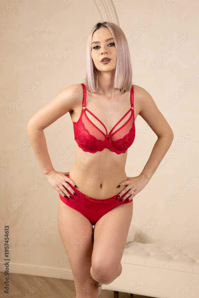 Fototapeta premium Woman in red lingerie posing with hands on hips