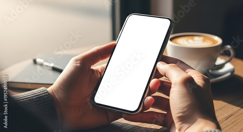 A person holding a smartphone with a blank screen in a cozy setting