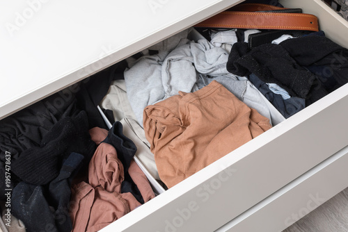 Foto Open dresser drawer with mixed casual clothes shows home wardrobe clutter, storage overflow and everyday organization problem