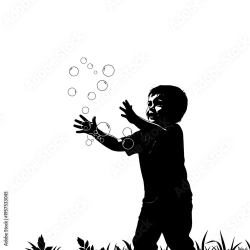 A silhouette of a young boy playing with bubbles in a field
