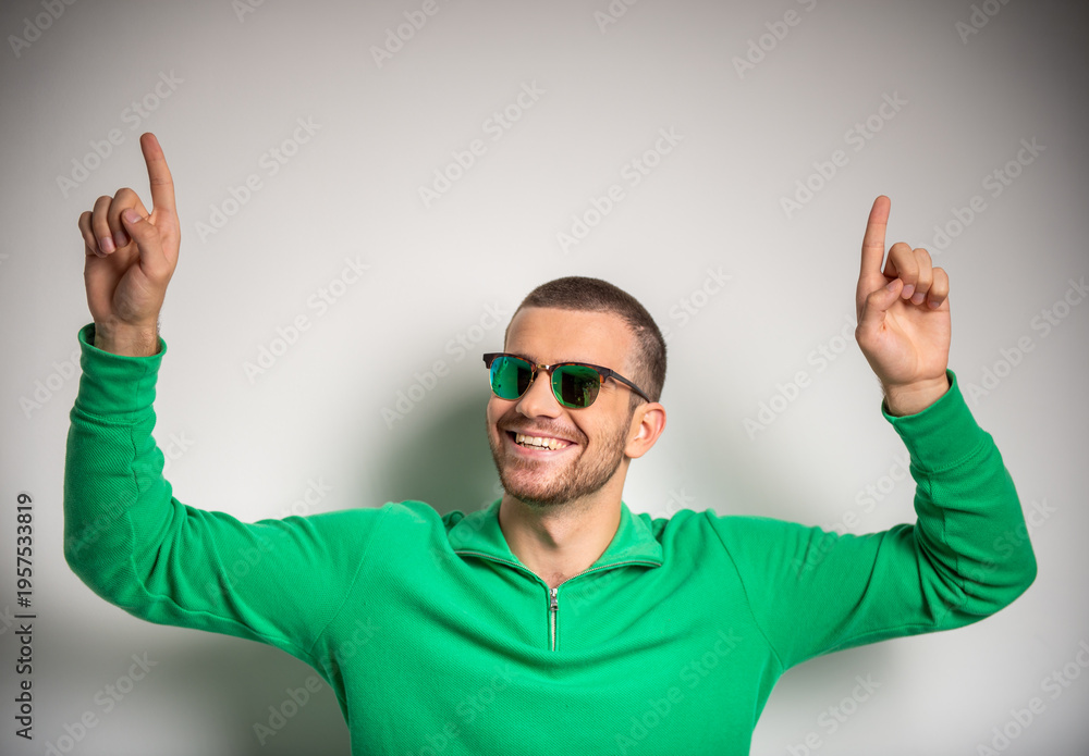 Naklejka premium Happy man pointing upward with both hands.