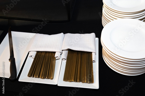 Dining setup with silverware and plates for an event in a formal setting