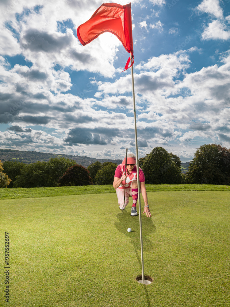 Obraz premium Senior female golfer contemplating shot on golf course green