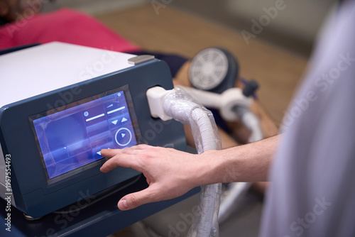 Man using therapeutic device with touchscreen in rehabilitation center
