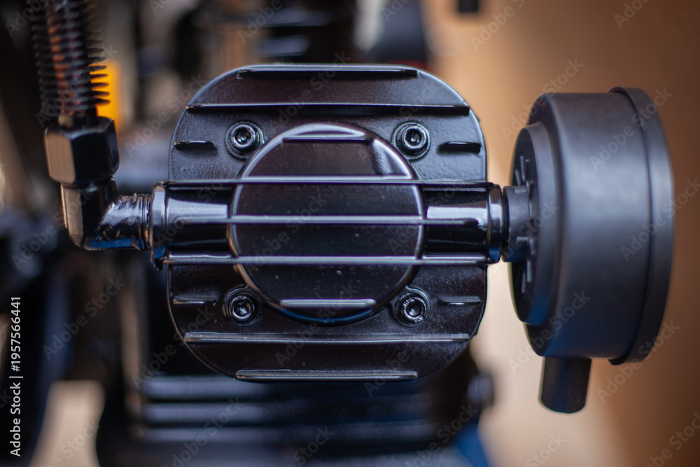 Fototapeta premium Industrial air compressor cylinder head with cooling fins and bolt assembly in black finish for heavy-duty mechanical engineering, thermal management, and pneumatic power system applications