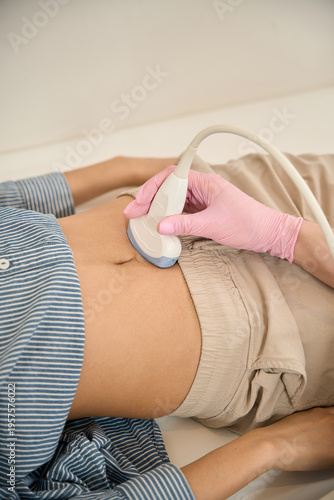 Adult undergoing ultrasound examination in medical room