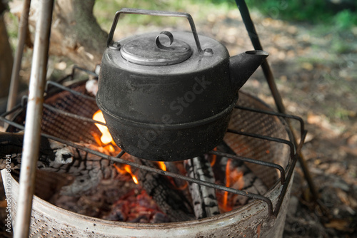 the kettle on a fire  at a campsite during daylight hours