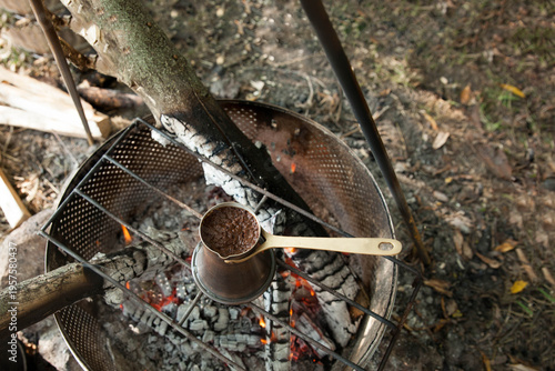 Turkish coffee pot on a fire  at a campsite during daylight hours