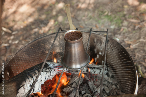 Turkish coffee pot on a fire  at a campsite during daylight hours