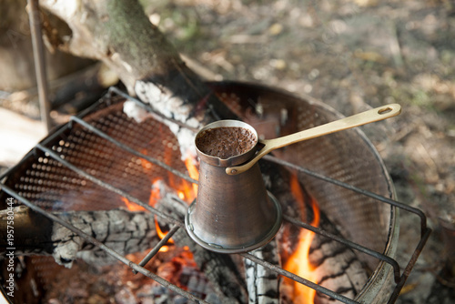 Turkish coffee pot on a fire  at a campsite during daylight hours