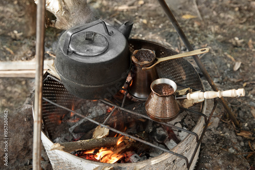 the kettle and the  turkish coffee pot on a fire  at a campsite during daylight hours