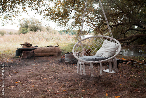 Cozy swing chair in a peaceful outdoor campsite setting during daylight hours