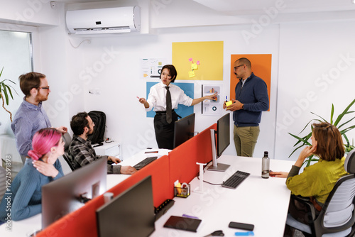 Business meeting in a modern office with diverse team discussing project strategies and ideas on a sunny weekday afternoon