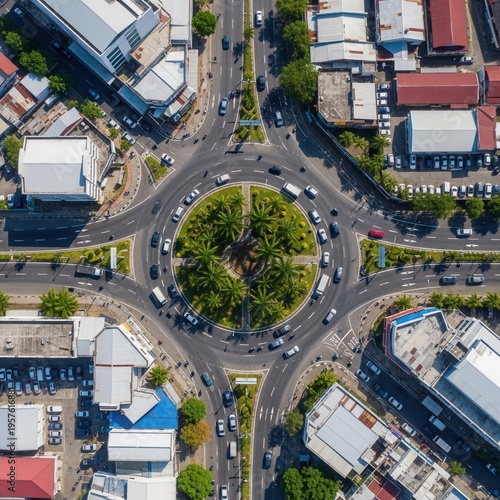 Aerial View Of Bustling City Roundabout With Traffic And Surrounding Buildings