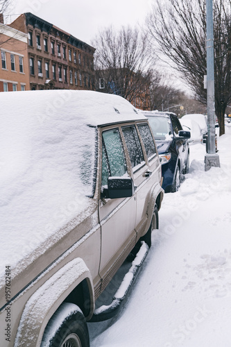 Snow-covered vehicles on urban winter streets