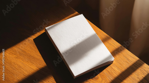 Blank booklet mockup on wooden desk with warm natural light and shadow stripes for branding design presentation