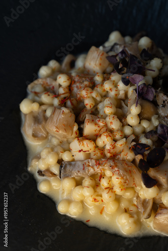 Fotografie Traditional Ukrainian kachana kasha served in a refined fine dining style on a black plate