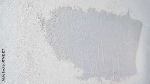 Applying putty to a plastered wall with a metal spatula producing a sharp squeaky sound, ASMR construction
