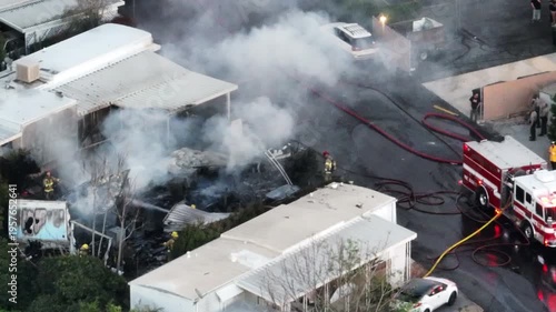 A Fire in Yucaipa, California with first responders and smoke coming from a trailer park
