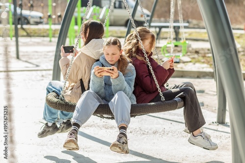 Teenage Girls Playing Video Games On Phones. Technology addiction concept