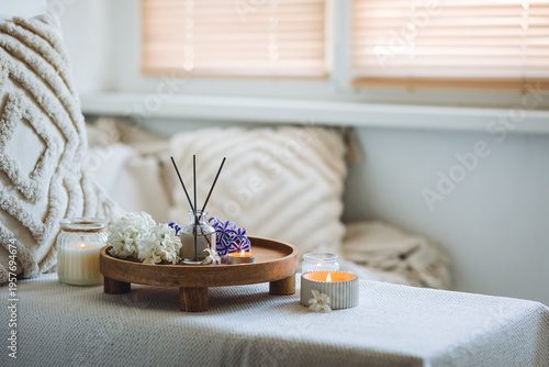 Concept of cozy home space for meditation, relaxation. Spiritual aura cleansing routine. Spring hyacinth blossom scent. Burning candles, aroma fragrance natural organic diffuser, wooden bamboo tray. 
