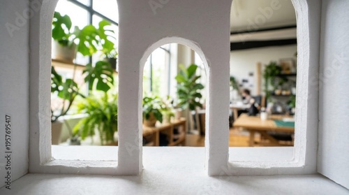 White architectural model with arch openings, conceptual prototype in modern design studio during daytime.