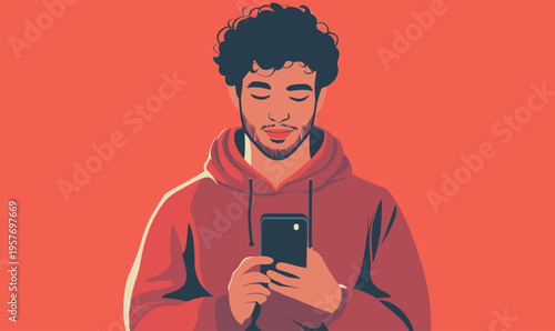 Young man with curly hair engrossed in his smartphone, wearing a red hoodie