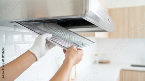 Photos Person in white gloves removing a metal filter from a kitchen range hood for cleaning 1