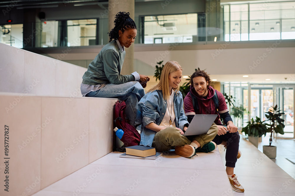 Obraz premium Multiracial group of happy students using laptop at university.