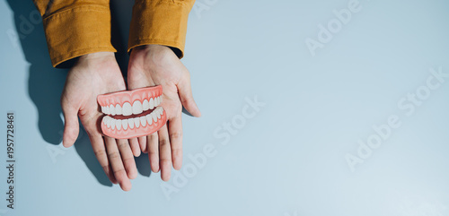 Photos Person holds large model of teeth in their hands, showcasing playful representation of dental health