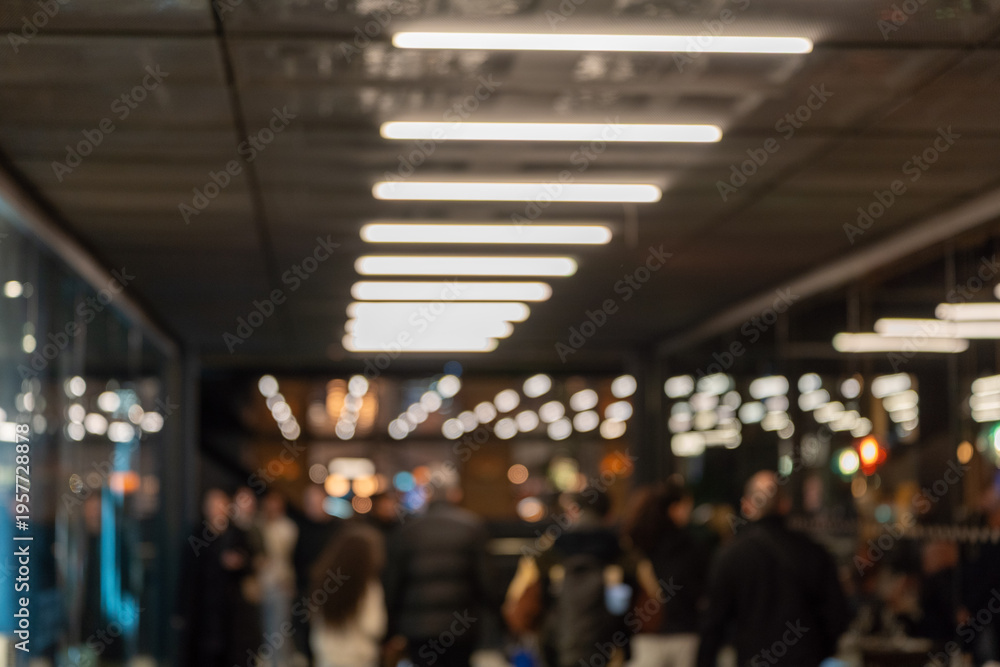 Fototapeta premium Blurry indoor crowd under linear ceiling lights