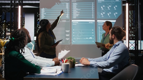 Cuadro en lienzo Multiethnic experts team evaluating data performance metrics on projection board, reviewing data insights with investors group in executive session after hours