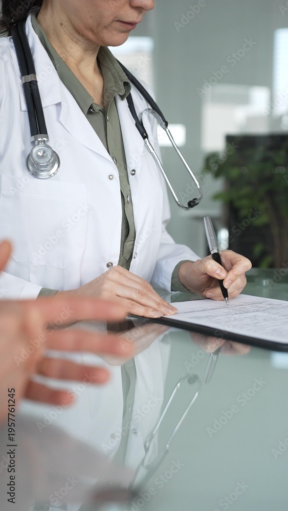 Obraz premium Doctor woman consulting patient, filling out medical records during a healthcare check up in a clinic. Medicine, healthcare and science concept